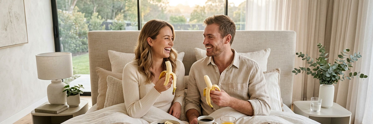 Pareja desayunando plátano por la mañana
